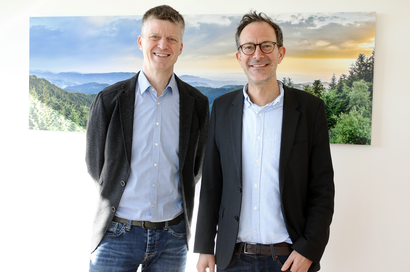Zwei Männer stehen vor einem Schwarzwaldbild